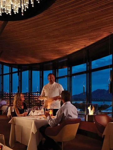 Elegantes Restaurant mit Panoramablick auf die Bucht bei Nacht