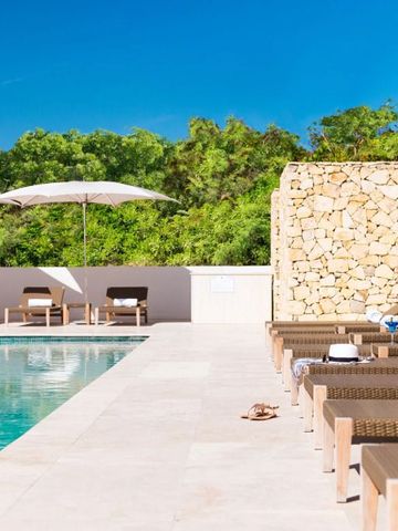 Sonnenschirme und Liegestühle am Pool mit Natursteinwand