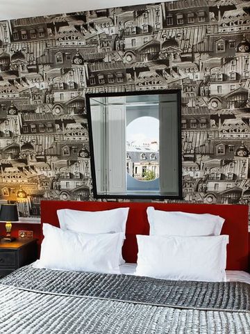 Luxuriöses Hotelzimmer mit stilvoller Wandtapete und rotem Kopfteil