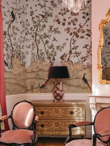 Eleganter Wohnbereich mit üppigen Tapeten und antiken Möbeln