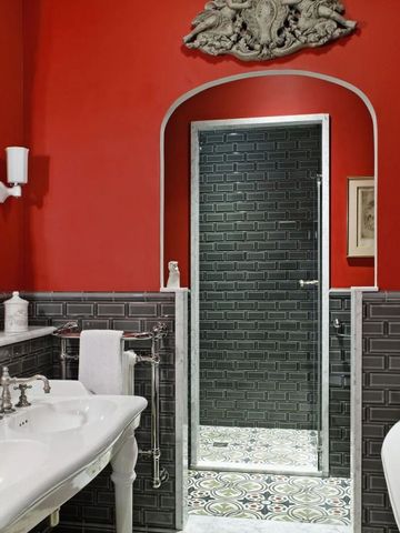 Luxuriöses Badezimmer mit roter Wand und eleganten Sanitärmöbeln im klassischen Stil