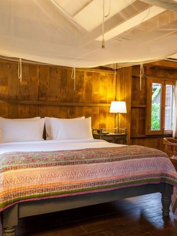 Gemütliches Schlafzimmer mit Holzverkleidung und Moskitonetz