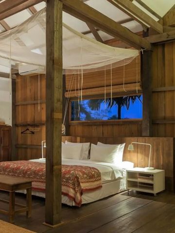 Großes Schlafzimmer mit Holzbalken und romantischer Beleuchtung