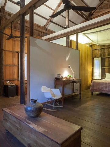 Geräumiges Schlafzimmer aus Holz mit Schreibtisch und beleuchtetem Bett