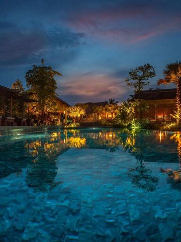 Pool bei Dämmerung mit Beleuchtung und umgebendem Garten