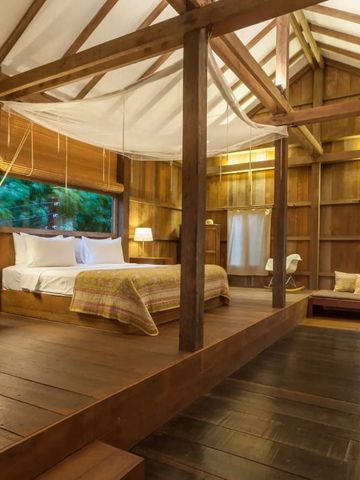 Großzügiges Schlafzimmer mit Holzboden und Himmelbett im traditionellen Stil.