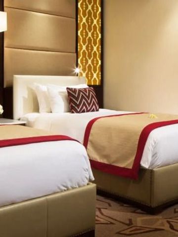 Zwei Einzelbetten in einem eleganten Hotelzimmer