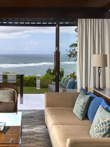 Luxus-Suite mit Meerblick und eleganter Einrichtung, großen Fenstern zur Terrasse.