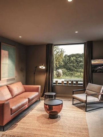 Gemütlicher Wohnbereich mit Ledersofa und großem Fenster mit Gartenblick im San Canzian Hotel