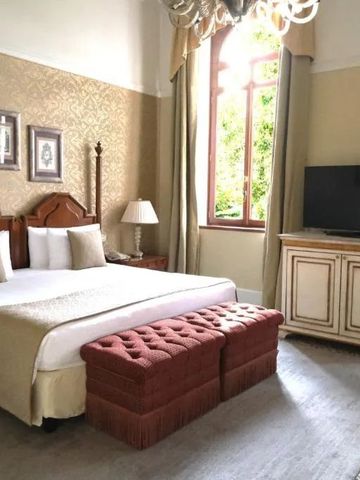 Luxuriöses Zimmer mit großem Fenster, Doppelbett und edler Einrichtung.