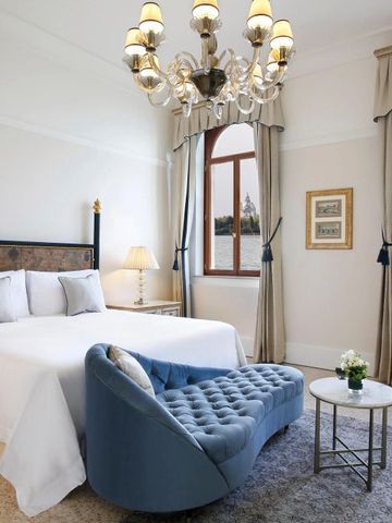 Helles Zimmer mit Blick auf Wasser, Doppelbett und Sofa.