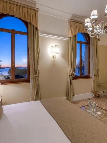 Helles Zimmer mit großem Fensterblick und stilvollem Kronleuchter.