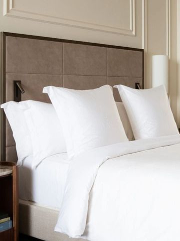 Elegantes Hotelzimmer mit hochwertigem Bettzeug und Blumendekoration