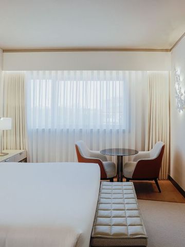 Helles Hotelzimmer mit Sitzbereich und großem Spiegel