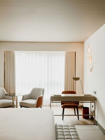 Modernes Hotelzimmer mit Schreibtisch und gemütlichen Stühlen