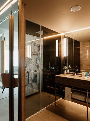 Modernes Bad mit Glaswand und stilvollem Waschbecken