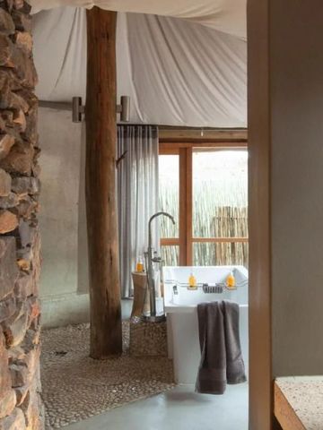 Rustikale Badezimmergestaltung mit Natursteinen und modernen Elementen.