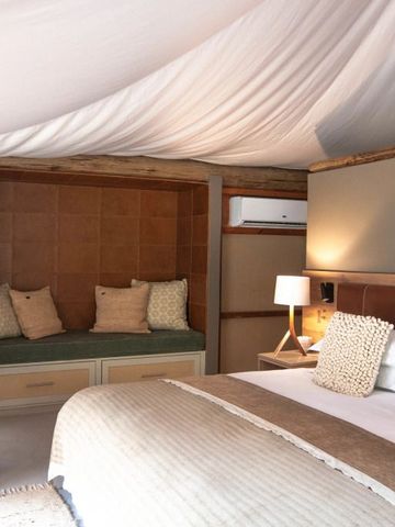 Luxuriöses Schlafzimmer mit gemütlichen Sitzgelegenheiten und Naturlampe.