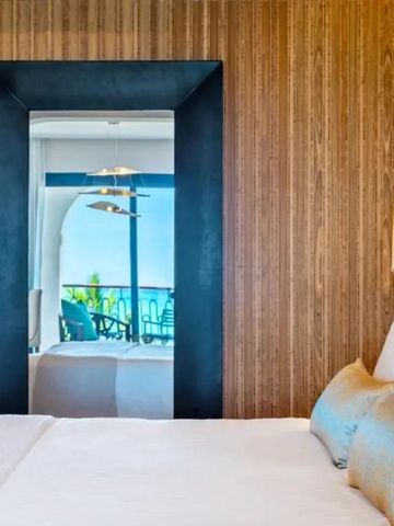 Zimmeransicht mit Spiegel, der den Balkon und das Meer reflektiert.