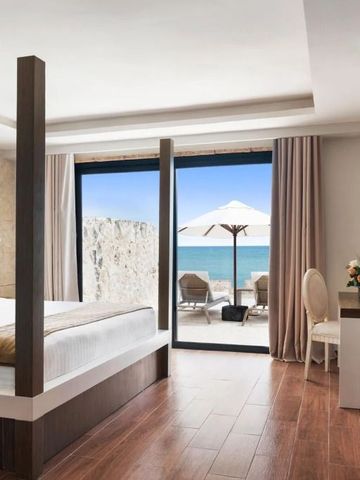 Elegantes Schlafzimmer mit Himmelbett und Terrasse zum Meer.