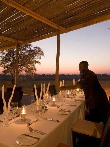 Abendessen im Freien mit Kerzenlicht unter einem Strohdach