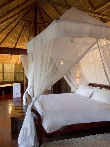 Luxuriöses Schlafzimmer mit Himmelbett und traditionellem Strohdach