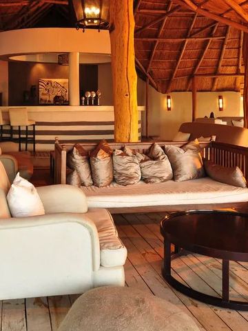 Weiträumige Lounge mit strohgedecktem Dach und modernen Möbeln