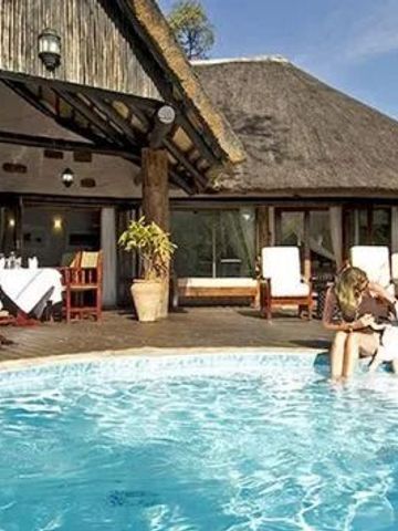 Poolbereich mit Dachterrasse und Essbereich im tropischen Stil