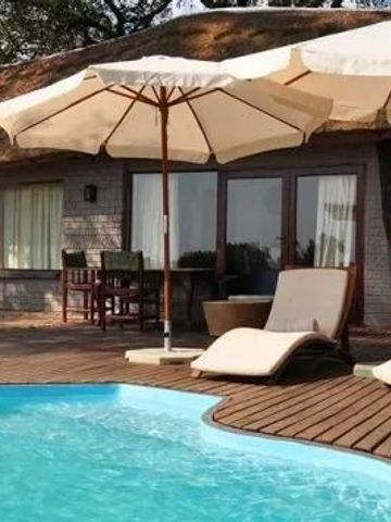 Privater Poolbereich mit Liegen und Sonnenschirmen vor einer luxuriösen Suite