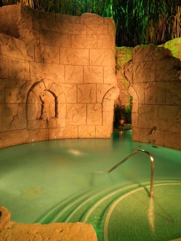 Geheimnisvoll beleuchteter Pool in natürlicher Steinumgebung