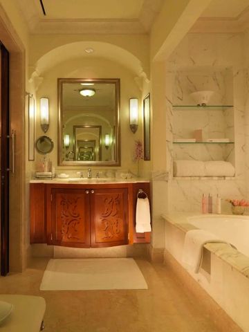 Luxuriöses Badezimmer mit Marmorverkleidung und eleganter Beleuchtung.