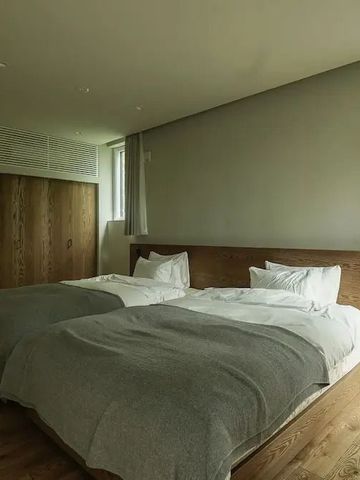 Modernes Doppelzimmer mit zwei bequemen Betten und Holzfußboden