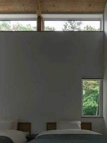 Modernes Schlafzimmer mit großen Fenstern und Naturblick