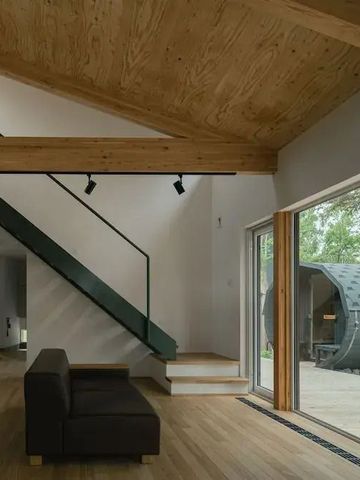 Geräumiger Wohnbereich mit Holzbalkendecke und Blick nach draußen
