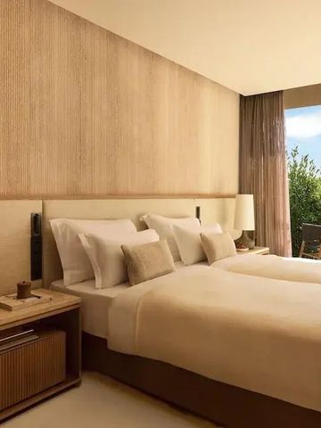 Komfortables Doppelzimmer mit großen Fenstern und Gartenblick im Sani Asterias Hotel