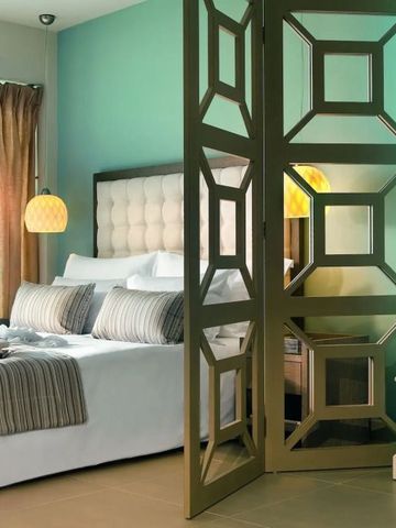 Moderne Hotelsuite mit Designertrennwand und gemütlichem Doppelbett