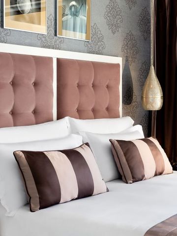 Detailansicht eines eleganten Hotelbetts mit stilvollen Kissen