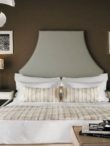 Elegantes Hotelzimmer mit stilvollem Bett und dekorativen Lampen