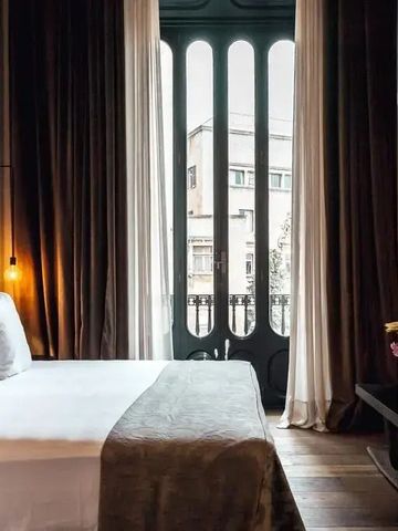 Luxuriöses Schlafzimmer mit großem Bett und hohen Fenstern