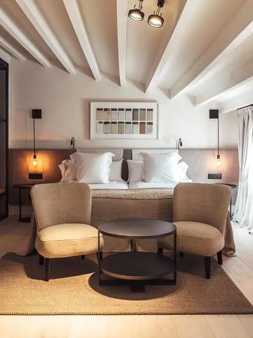 Charmantes Schlafzimmer mit Holzbalkendecke und gemütlichen Sesseln