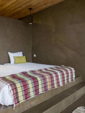 Geräumiges Schlafzimmer mit modernem Design und farbenfroher Bettdecke im Santa Barbara Eco Beach Resort.