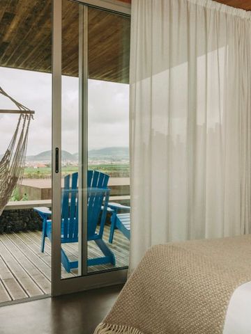 Zimmer mit Blick auf Balkon mit Hängematte und Bergblick