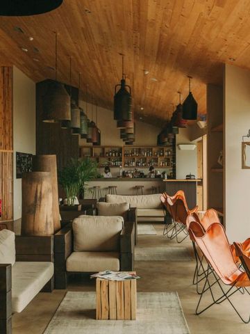 Stilvolle Hotelbar mit Designerstühlen und natürlichem Holzdekor