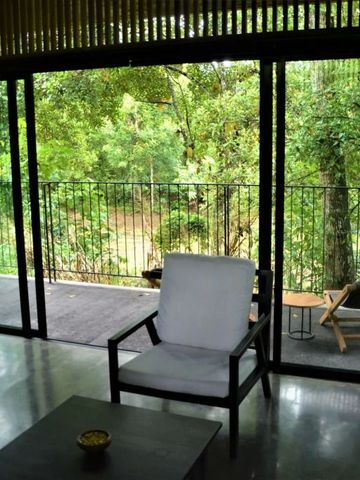 Zimmerausblick auf eine grüne Terrasse mit Sitzmöbeln