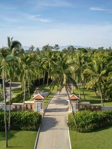 Einfahrt mit Palmen und grünen Gärten im Resort auf Koh Samui.