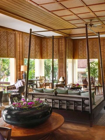 Elegante Hotel-Lounge mit Holzverkleidung und großen Fenstern zur Gartenansicht