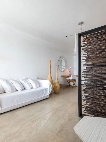 Minimalistische Sitzecke mit weißen Möbeln und Bambusdeko