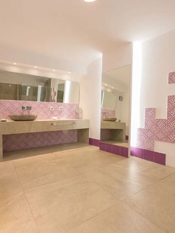 Badezimmer mit pink-weißen Fliesen und modernem Waschbereich
