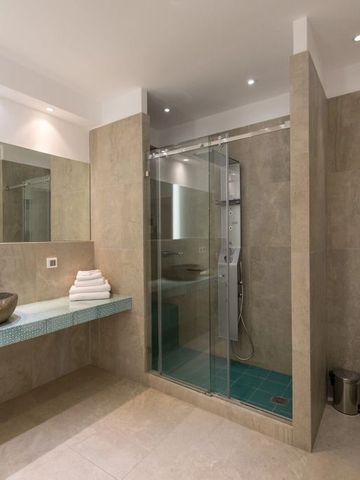 Geräumiges Badezimmer mit Glasdusche und Marmorwaschbecken