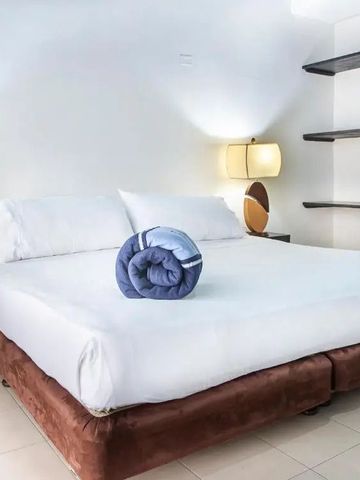 Helles Schlafzimmer mit einem großen Doppelbett und stilvollen Lampen